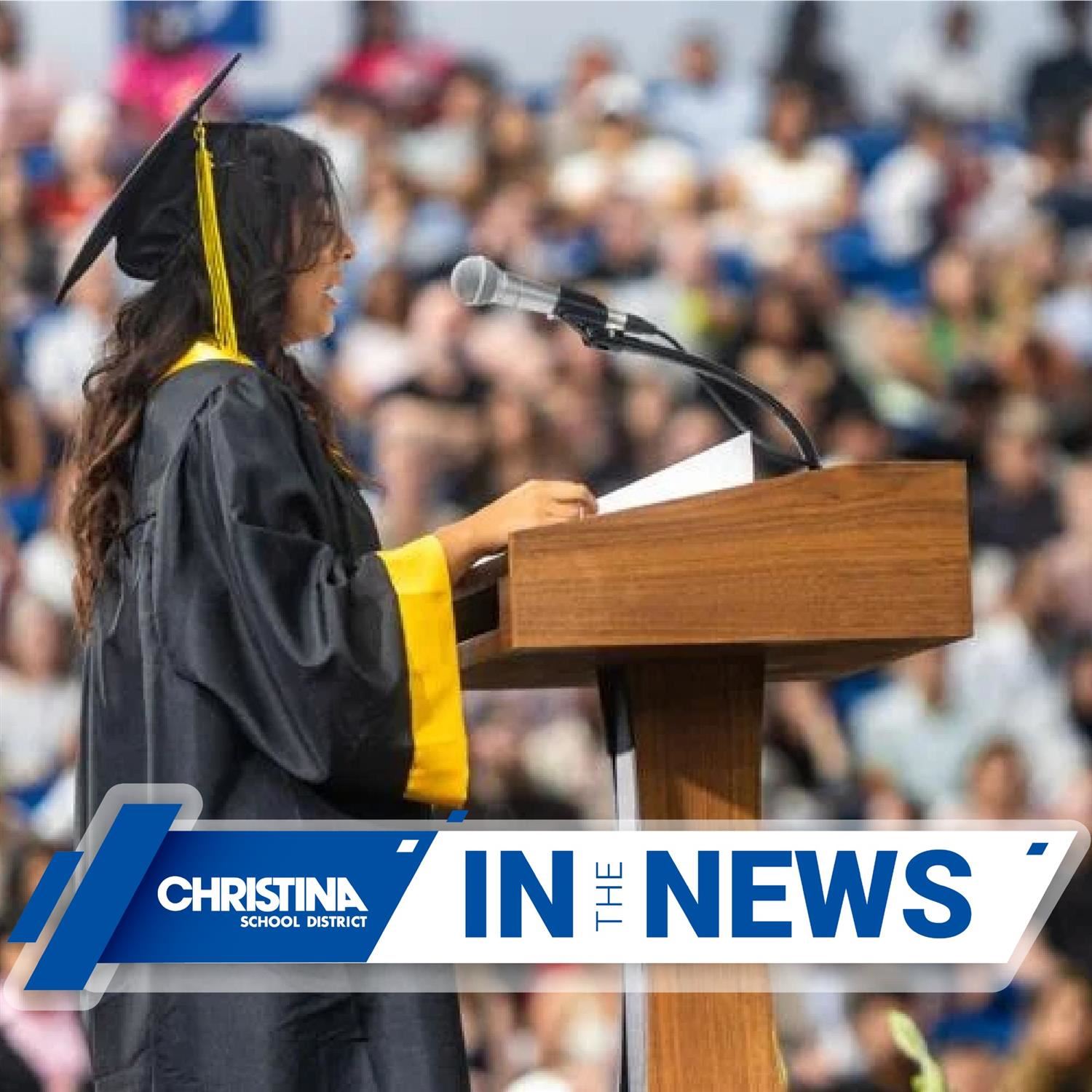 Female student dressed in cap and gown from Newark HS speaking at podium during graduation